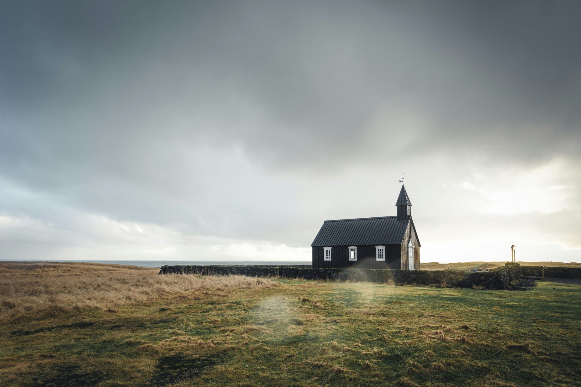 Black church in grassy landscape
